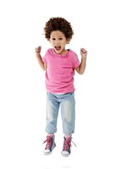 Sneakers Prints: Because Im happy. Studio shot of a cute little girl jumping for joy against a white background