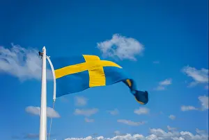 National Symbol Prints: Image of a flagpole with the flag of sweden flying, on a background of blue sky
