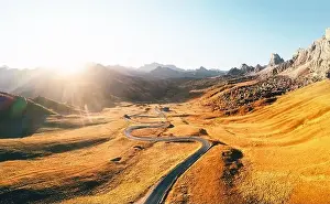 Giau Prints: Incredible aerial view on winding road in autumn mountain valley at sunset