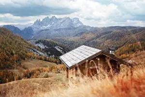 Incredible autumn view at Valfreda valley in Italian Dolomite Alps. Wooden cabin, yellow grass