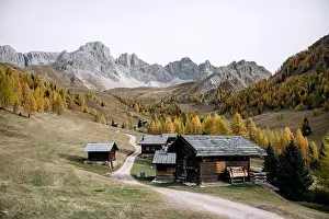 Incredible autumn view at Valfreda valley in Italian Dolomite Alps. Wooden cabins, yellow grass