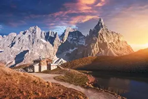 Incredible landscape with a reflection of purple sky and mountains in a water of small lake in a popular tourist destination - Baita Segantini