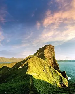 Incredible sunset landscape with Kallur lighthouse on green hills of Kalsoy island, Faroe islands, Denmark