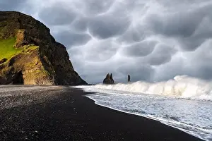 Incredible view on Black beach and Troll toes cliffs in cloudy weather. Stormy sky with menacing mammatus clouds on background