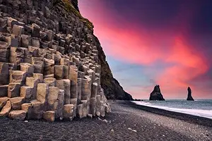Incredible view on Black beach and Troll toes cliffs in sunset time. Great purple sky glowing on background. Reynisdrangar, Vik, Iceland