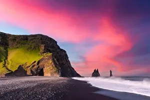 Incredible view on Black beach and Troll toes cliffs in sunset time. Great purple sky glowing on background. Reynisdrangar, Vik, Iceland