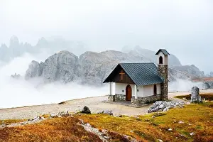 Incredible view on small chapel in the Tre Cime Di Laveredo National Park in morning fog. Dolomite Alps mountains, Trentino Alto Adige region