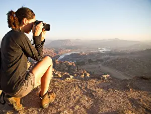 One Young Woman Only Prints: India, Karnataka, Young female tourist photographing on top of hill in Hampi