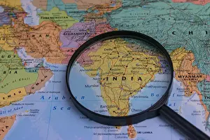 Loupe Prints: India map through magnifying glass on a world map