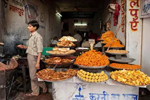 Piles Prints: indian boy making tradition sweets in shop
