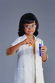 Spectacles Prints: Indian child girl in fancy dress costume of scientist holding test tubes with chemicals ; India ; Asia ; MR#495