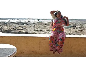 Saree Prints: an indian local woman in saree poses at the beach front at the slum area of chimbai village