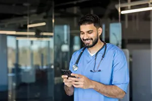 Browsing Prints: Indian male doctor wearing blue scrubs and a stethoscope