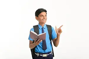 Clever Prints: Indian school boy in uniform and reading diary on white background
