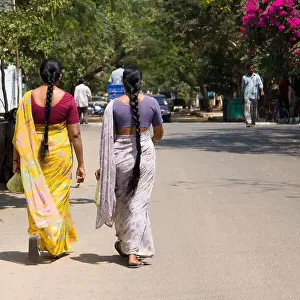 Indian Woman Prints: Two Indian woman with long plats dressed with saris walking on the street