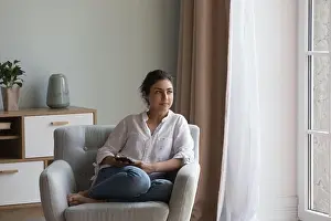 Dreaming Prints: Indian woman resting on cozy armchair staring into distance