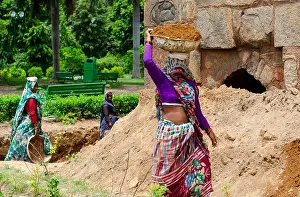 Indian Woman Prints: Indian women working on construction industry outdoors carrying sand on head for building