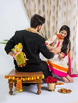 Sister Prints: Indian young sister tying rakhi on brother's wrist