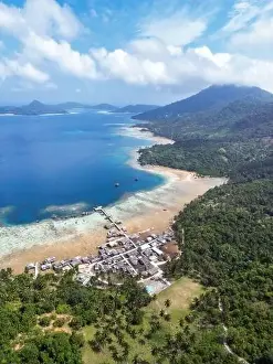 Indonesia Anambas Islands - Drone view Telaga Island coast line with village and vulcano
