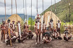 Indonesia, Papua, city of Wamena, group of Dani tribe warriors, armed with spears and posing in front of their huts