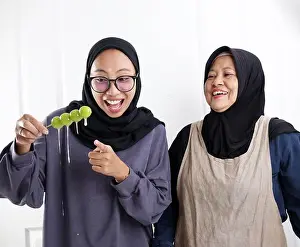 Drip Prints: Indonesian Muslim Mom and Daughter Happy Making Fruit Shine Muscat Covered with Sugar or Tanghulu in the Kitchen