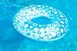 Inflatable Prints: inflatable swimming circle in blue open-air pool in summer day