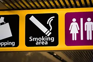 Nicotine Prints: Information sign at an airport indicating the way to the smoking area