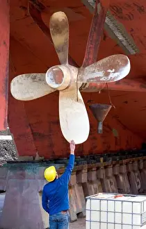 Arm Raised Prints: Inspecting the propeller of HMNZS Resolution in dry dock at the Devonport Naval Base in Auckland