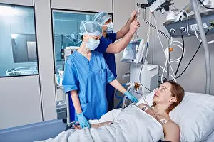 Ward Prints: Intensive care patient. Nurses attending to female patient in intensive care unit of hospital