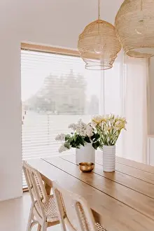 Spacious Prints: An interior shot of a contemporary styled living space with a wooden table and vases full of flowers