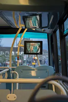 Cctv Prints: The interior of the upper deck of a double decker bus in London, with a CCTV screen