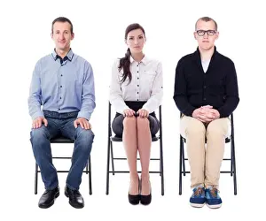 Stressful Prints: interview concept - young people sitting on office chairs isolated on white background