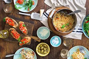 Tomatoes Prints: Italian dinner table with pasta, appetizers and white wine, top view