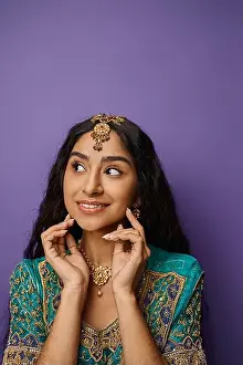 Sari Prints: joyful young indian woman in traditional attire smiling and looking away with hands near ace