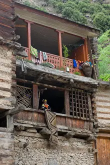 Kalash Prints: Kalash woman in traditional dress on the verandah of a Kalash house at Krakl Village