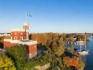 Kastellholmen red castle on island with Stockholm skyline in the background on a sunny autumn morning with turning