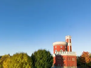 Kastellholmen red castle on island in Stockholm in a sunny autumn morning with turning yellow and orange trees in Sweden
