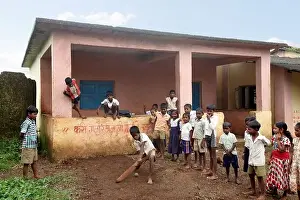 Katkari tribal children playing cricket in school campus, Maharashtra, India