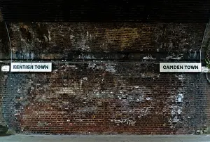 Camden Prints: Kentish Town and Camden direction signs under Victorian railway bridge that divides the two areas