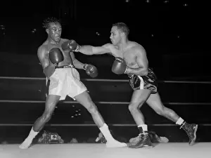 Boxer Prints: Kid Gavilan takes a punch from Walter Byars during a boxing match in Chicago in 1957
