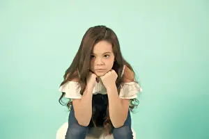 Preteen Prints: Kid prop chin on hands on blue background