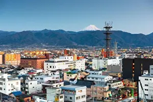 Fuji Prints: Kofu, Japan city skyline with Mt. Fuji peaking over the mountains at dusk