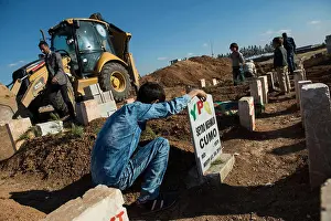 Kurdistan Prints: A Kurdish boy stands next the grave of his father