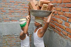 Brick Wall Prints: Labor carrying brick on head at construction site
