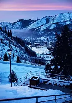 White Water Prints: Landscape of glowing Medeu skating rink from top view of stairs health in Tian Shan mountains at pink sunset in Almaty
