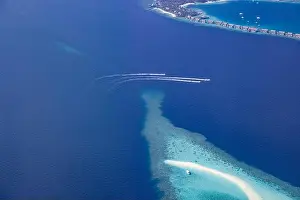 Landscape seascape aerial view over Maldives luxury resort villas with atoll sandbank island. Jet skis having fun in ocean lagoon. Luxurious summer
