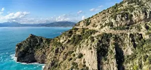A landscape view of the Costa di Maratea with a narrow and winding coastal highway in the cliffside