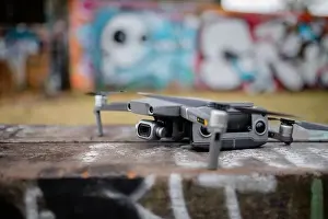 Remote Control Prints: Landscape View of a Gray Drone with A Blurry Graffiti Wall in the Background