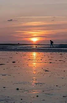Yellow Buoy Prints: Langrune-Sur-Mer, France - 07 21 2023: View of a man and a couple walking on the beach