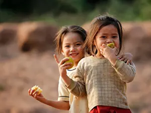 Grinning Prints: Lao Girls smiling on the banks of the Mekong